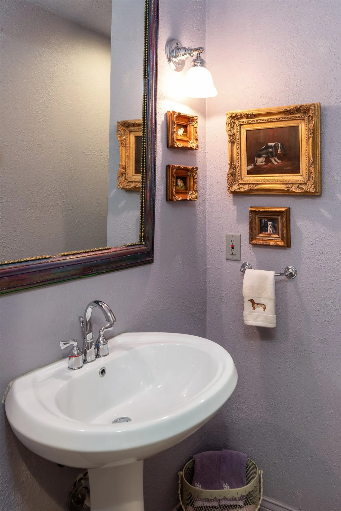 Powder Room featuring a white pedestal sink with a chrome faucet, illuminated by a wall-mounted light fixture
