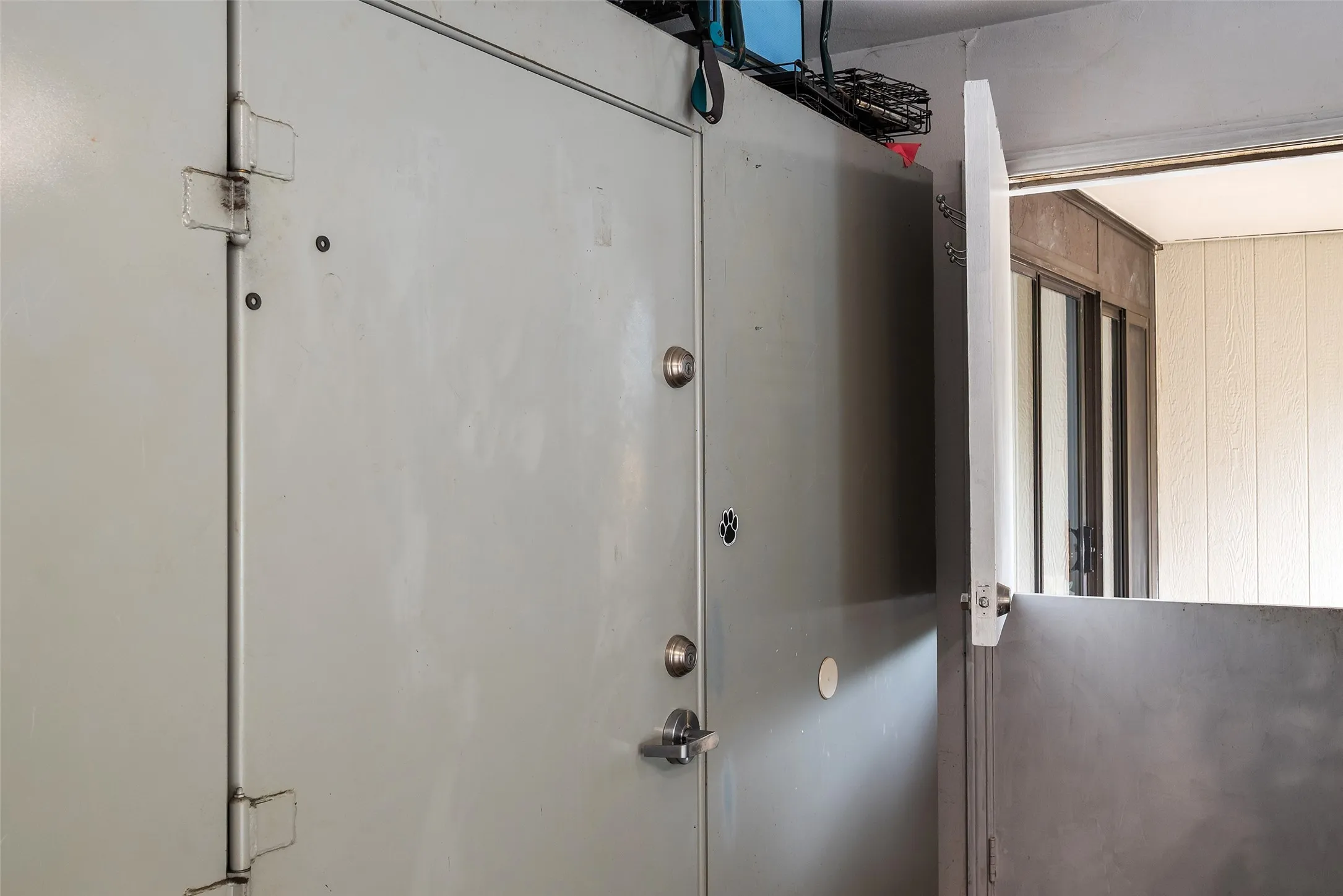 Exterior view of a security door of the Safe/Storm Room in the garage.  Dutch-door from garage to side yard.