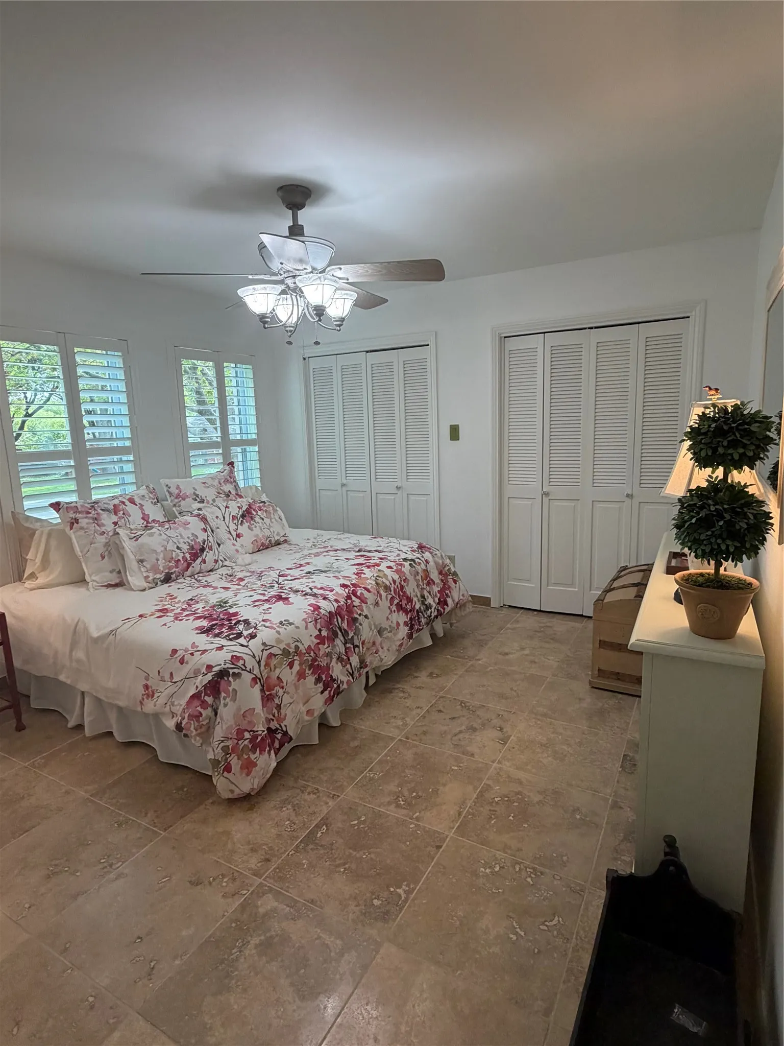 Refreshed painted walls, louvered bi-fold closet doors, ceiling fan with integrated lighting, and plantation shutters