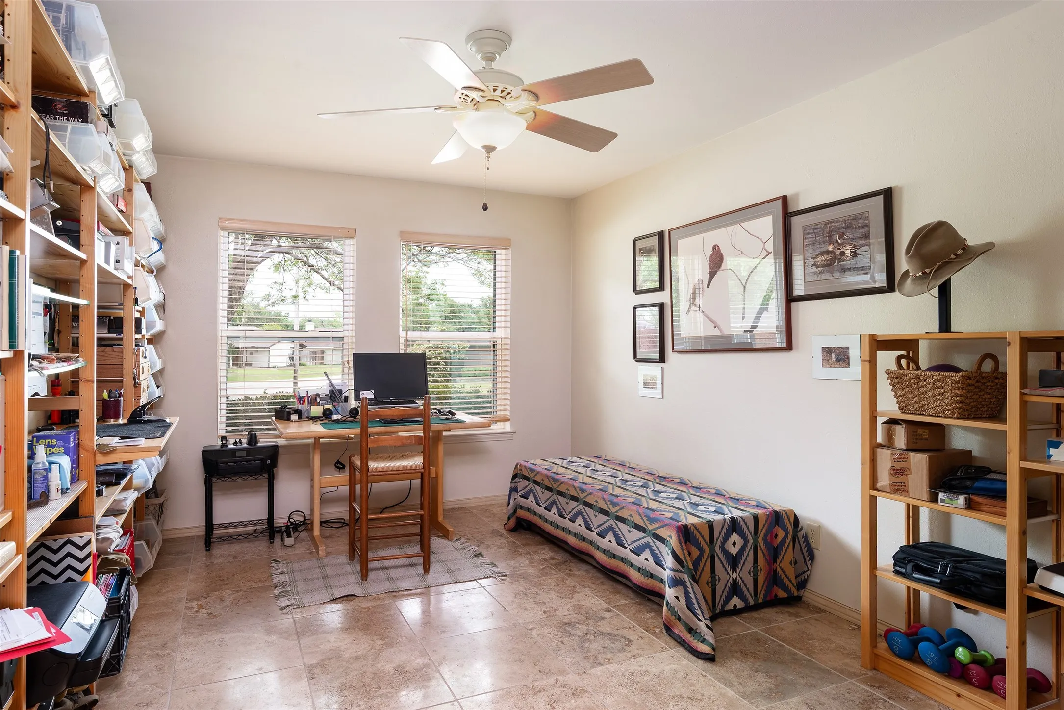 This room features tiled flooring, two windows with blinds, and a ceiling fan