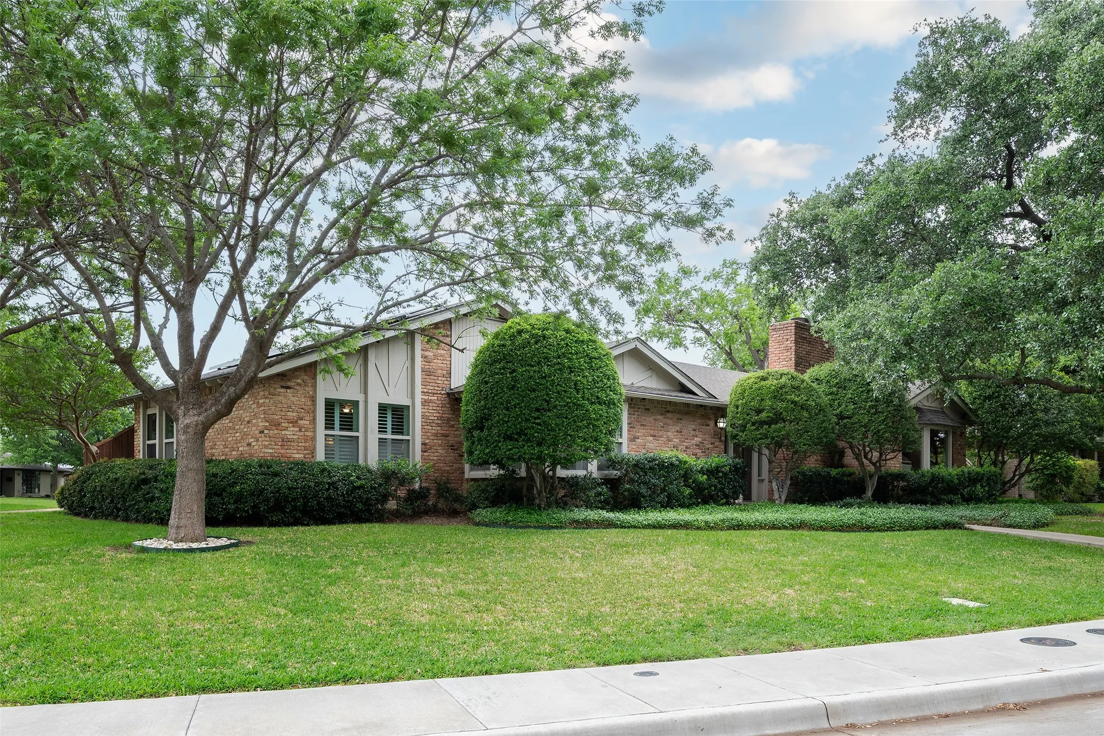 The property features a brick exterior with white siding accents and a pitched roof