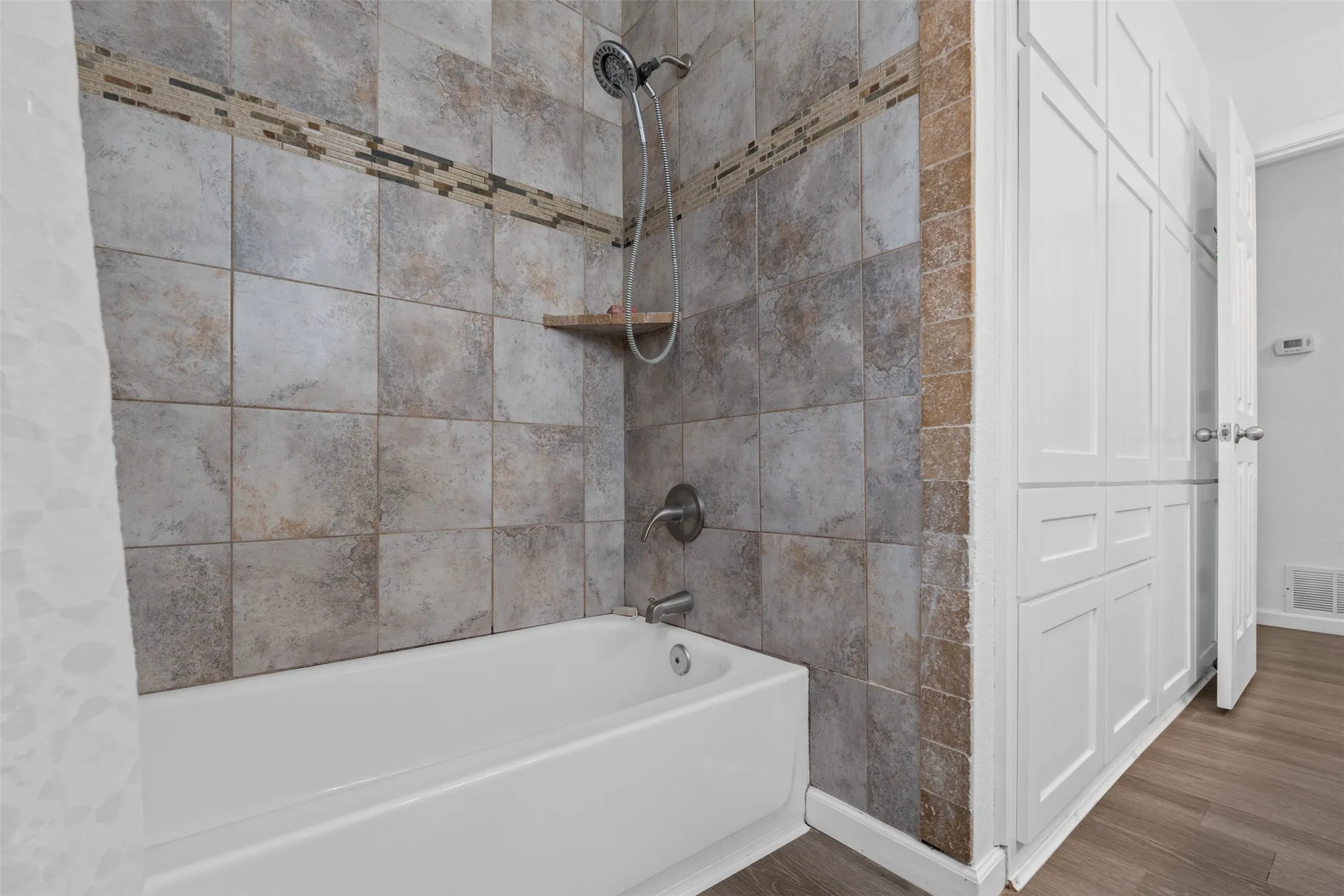 Hall bathroom has this lovely tile shower & tons of extra storage cabinets!