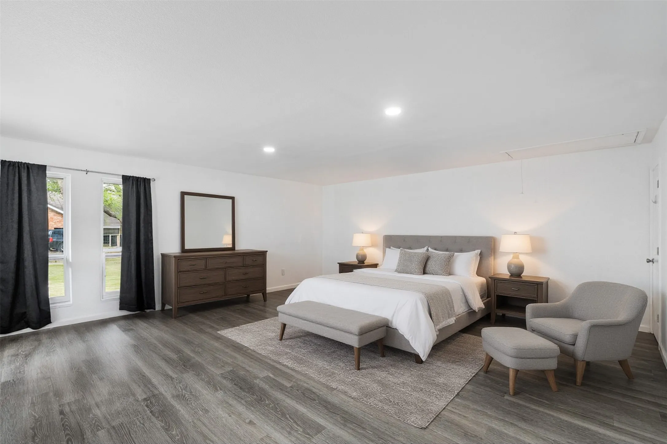 5TH BEDROOM - 3RD LIVING ROOM: Digitally staged as a second primary bedroom for this photo.