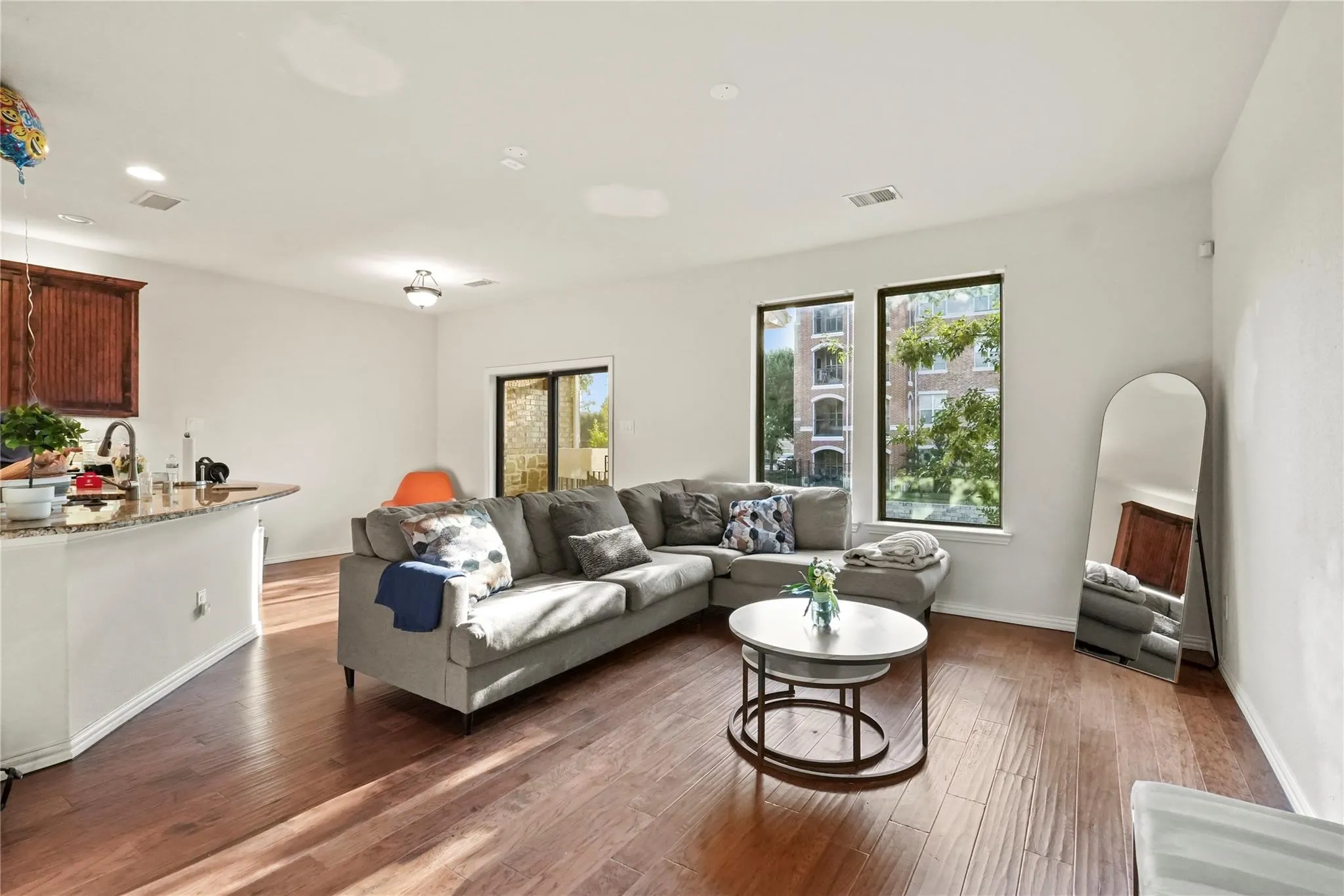 Living area with dark wood-type flooring and recessed lighting