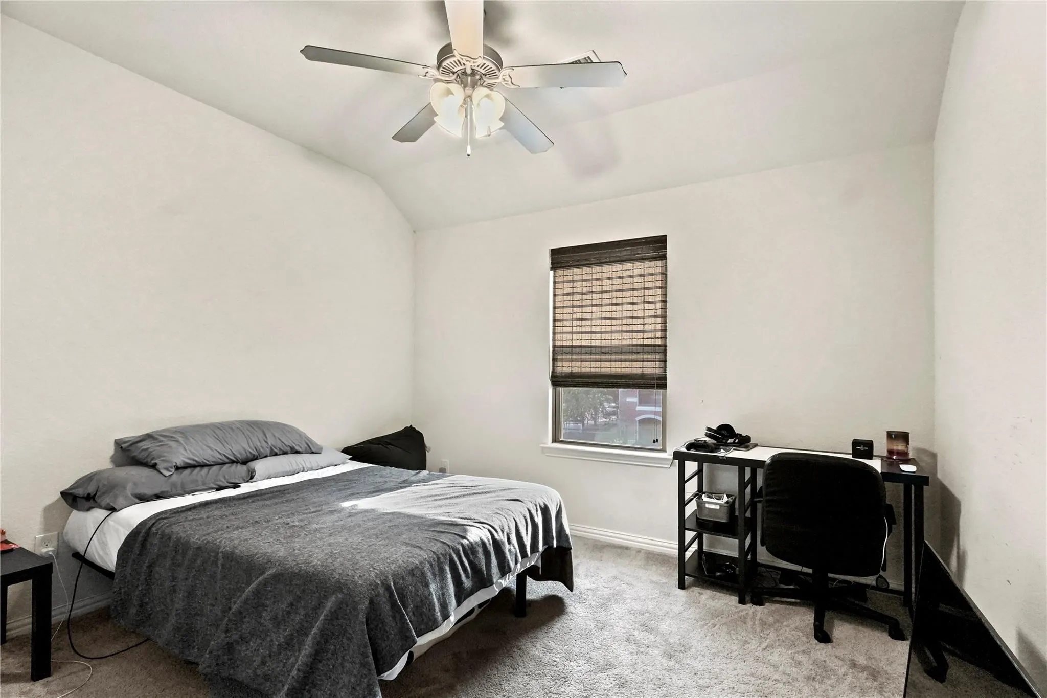 Bedroom featuring light carpet, lofted ceiling, ceiling fan, and an office area