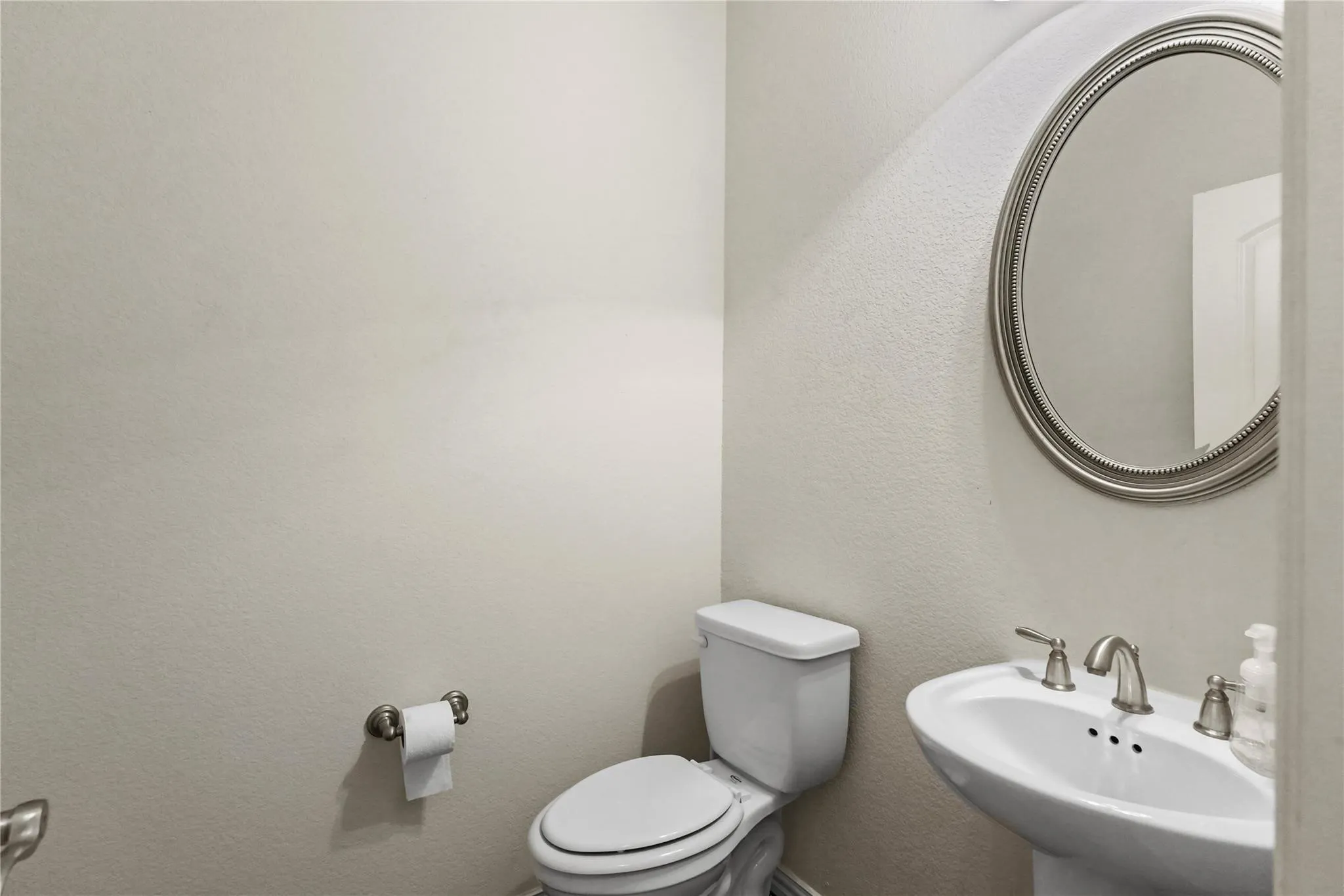 Half bathroom with toilet and a textured wall
