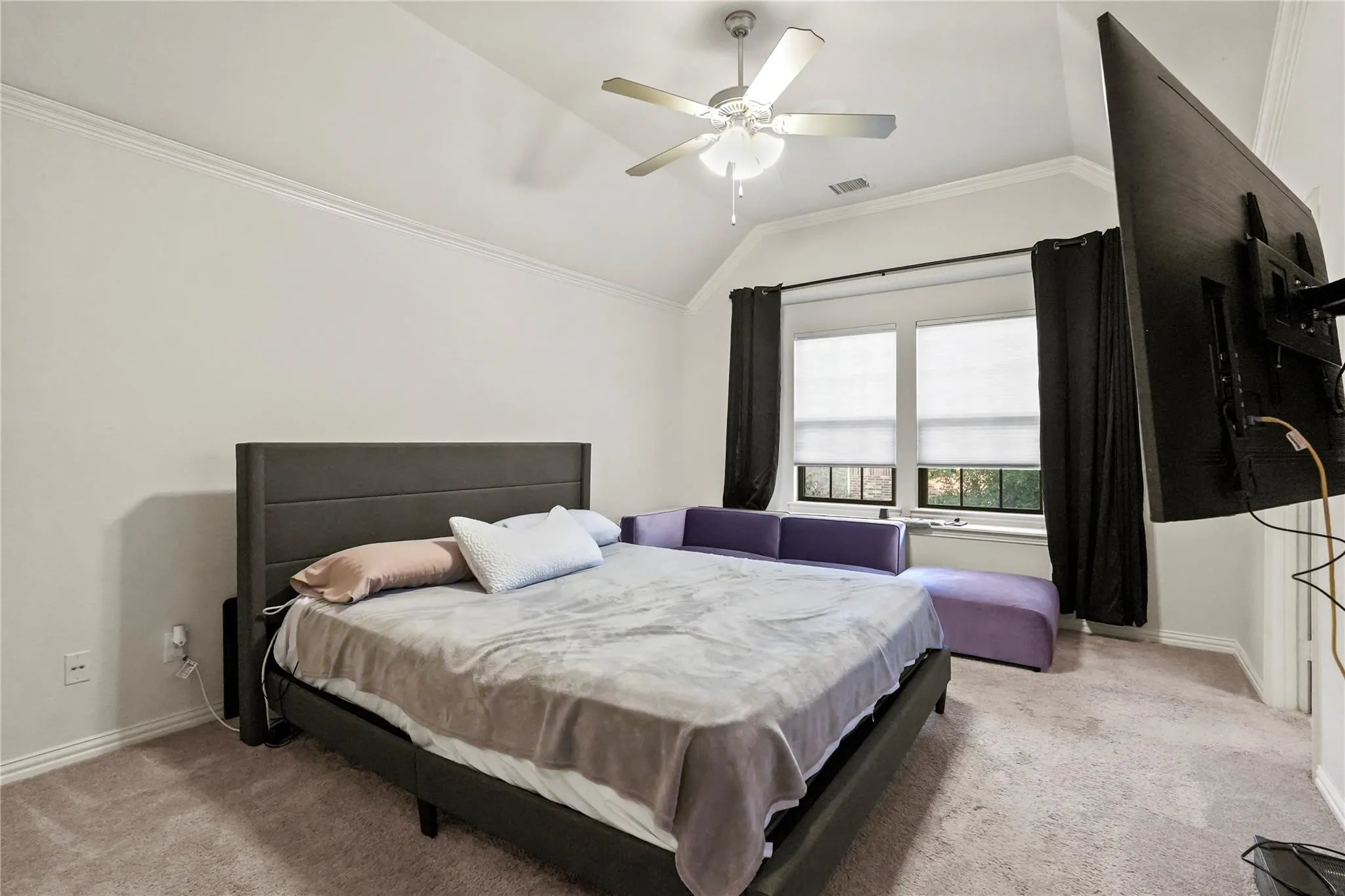 Bedroom with lofted ceiling, ornamental molding, light carpet, and ceiling fan