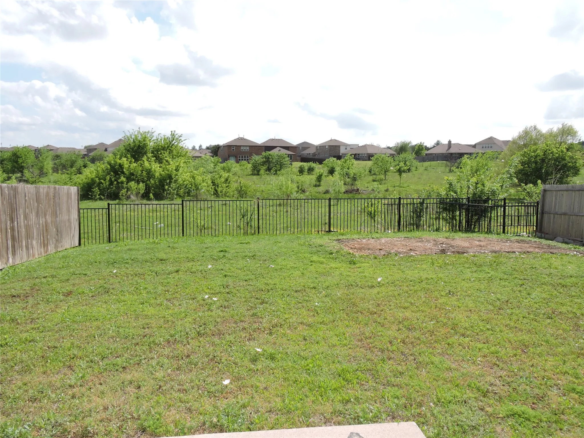 The property features a fenced backyard with a lawn