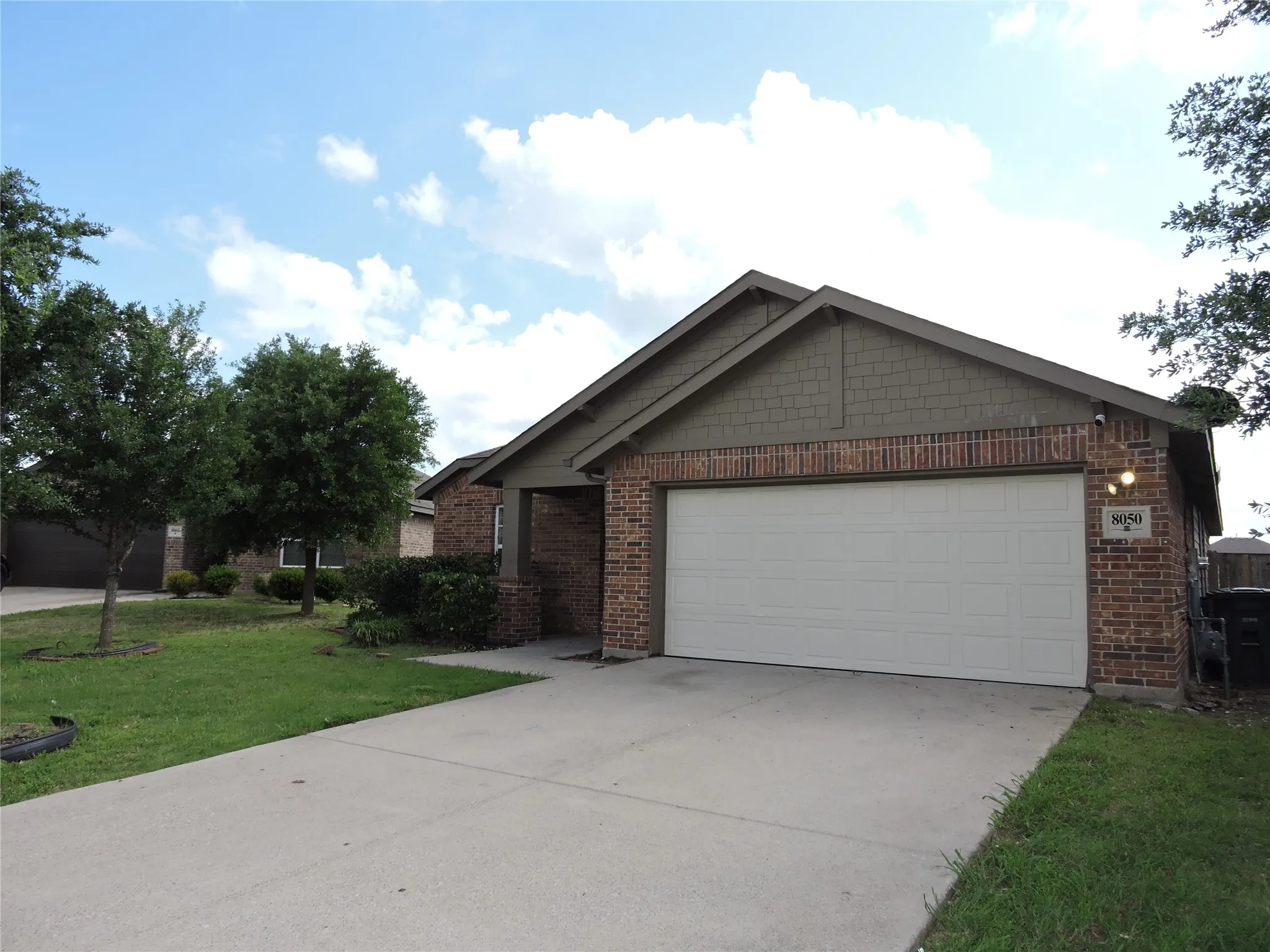 The property features a brick exterior with a gabled roof and a two-car garage