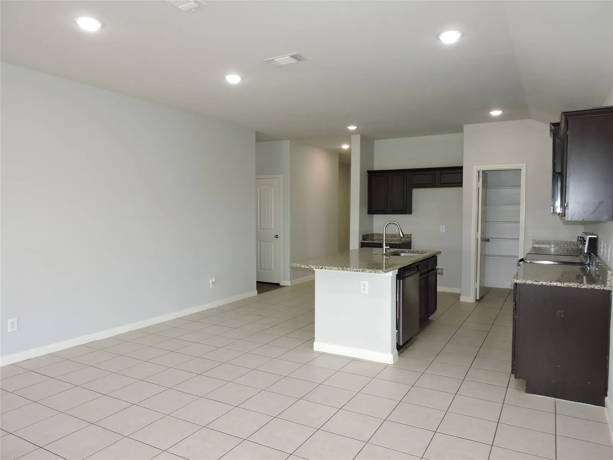 The property features an open-concept living area with tile flooring and recessed lighting