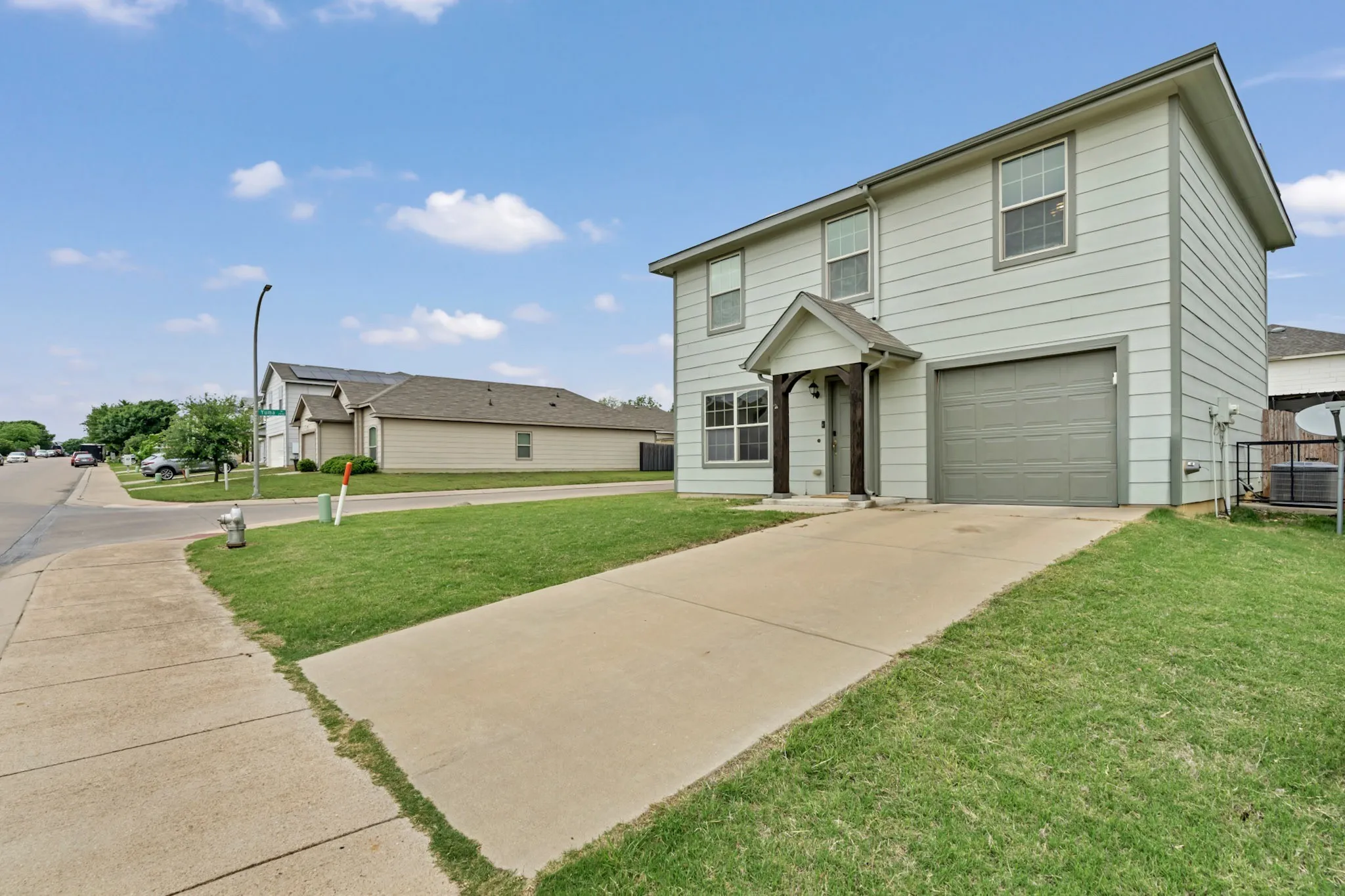 The property features a two-story exterior with siding, a front-facing garage, and a concrete driveway