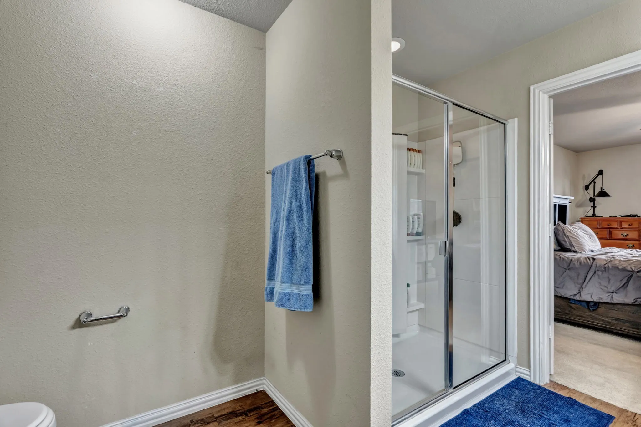 The property features a walk-in shower with a clear glass enclosure and a white tiled interior