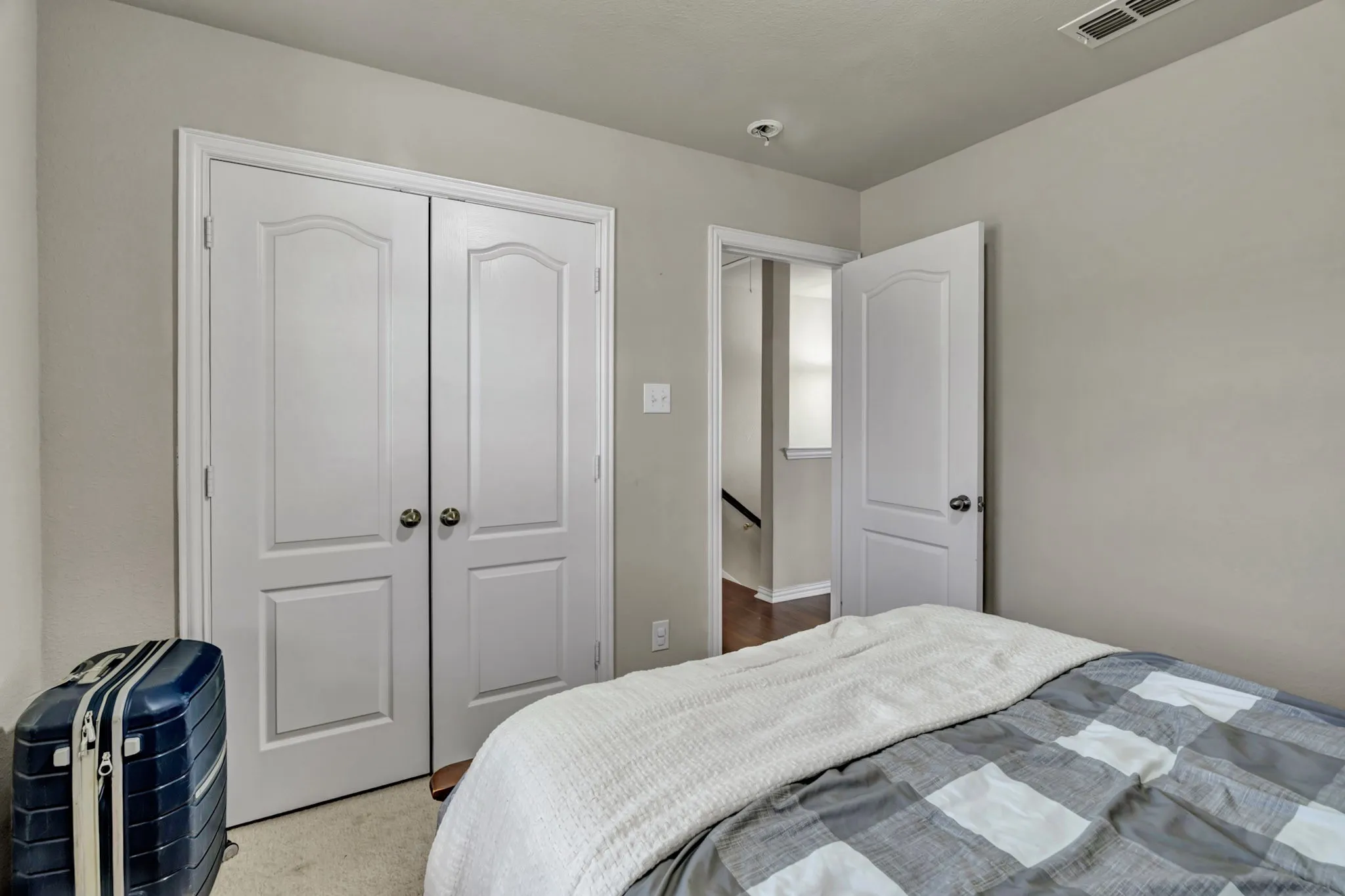 The room features light gray walls, white paneled doors, and carpeted flooring