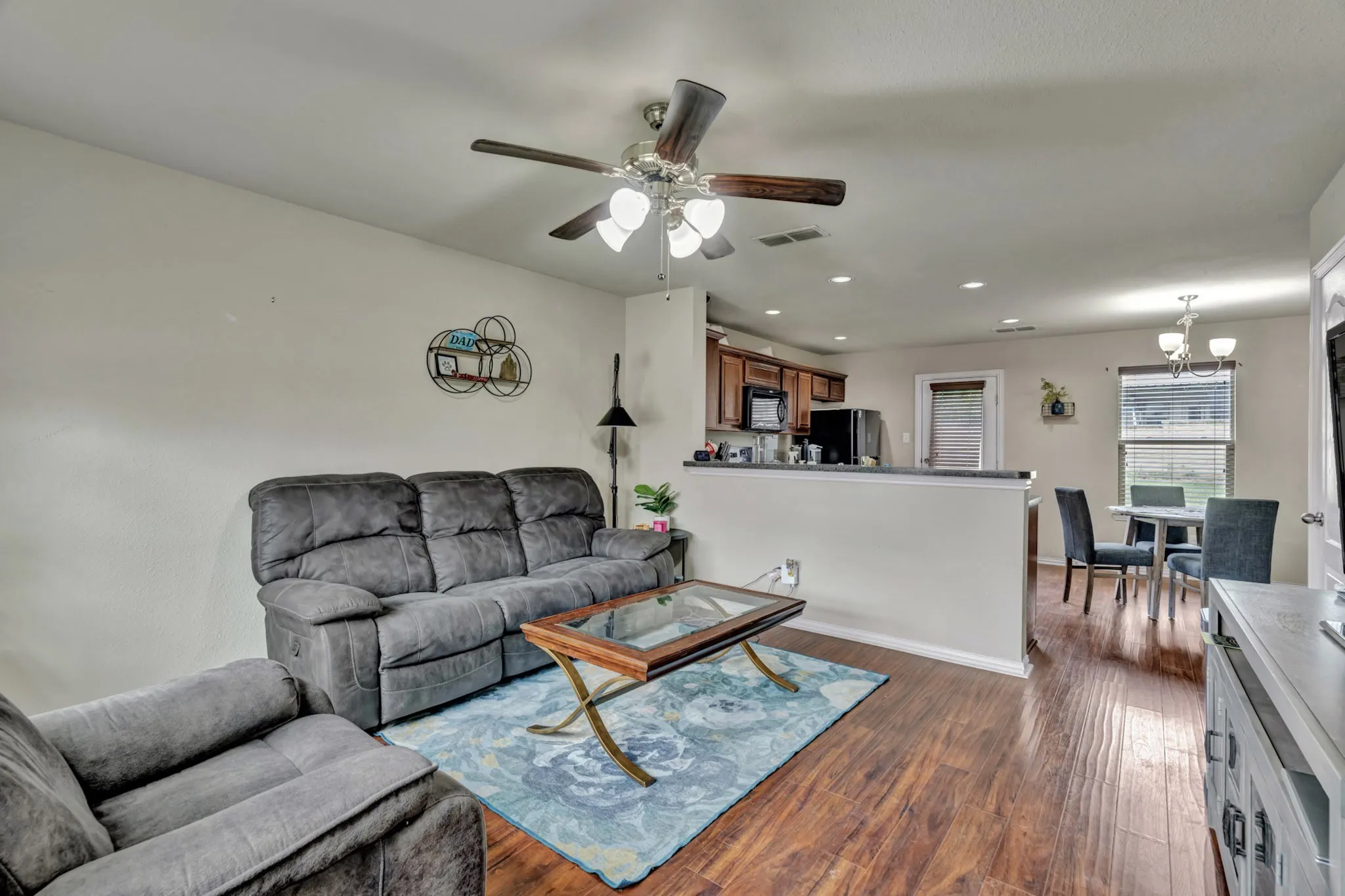 Living area featuring wood flooring, a ceiling fan, and recessed lighting