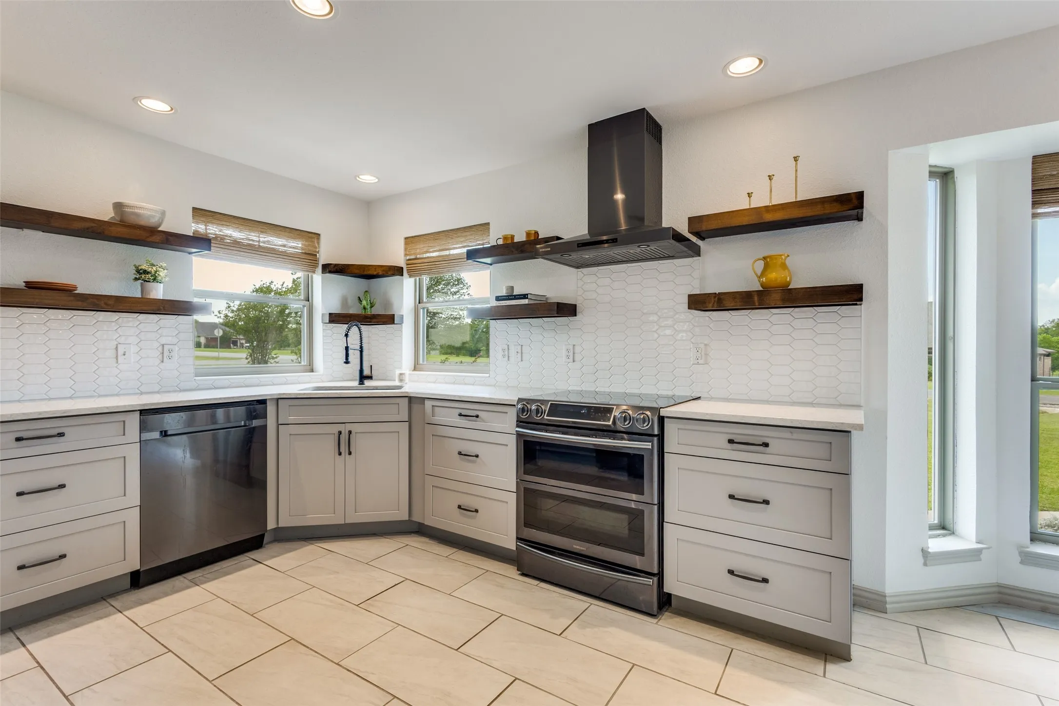 The kitchen features light-colored floor tiles, light-colored cabinetry with dark hardware, and white countertops