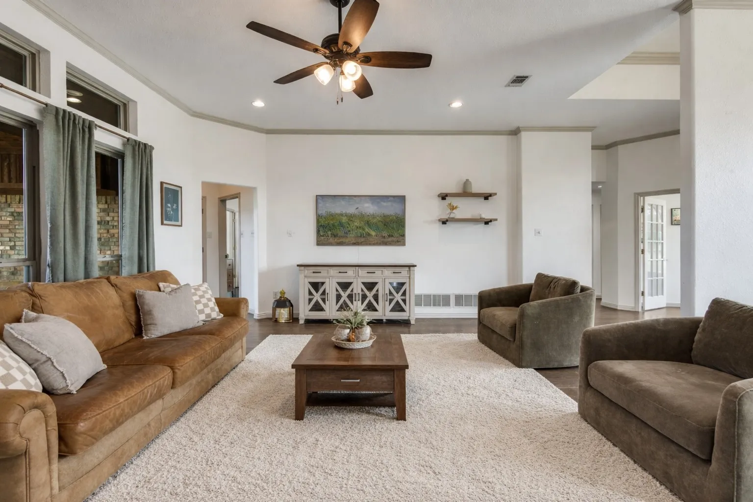 Spacious living room featuring hardwood floors, a ceiling fan, recessed lighting, and large windows with curtains