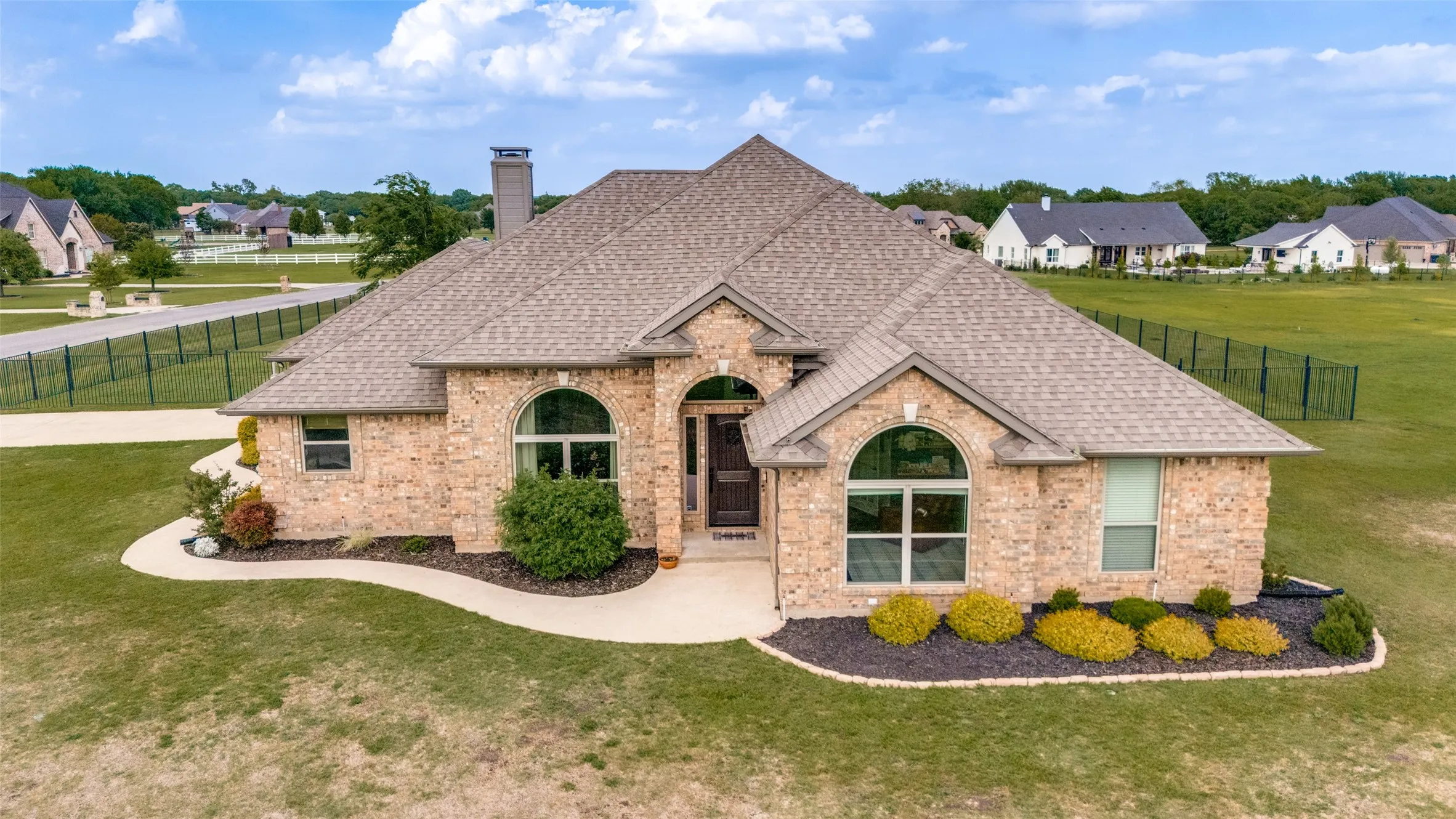 Property Exterior. Aerial perspective of a single-story brick structure with surrounding landscape features