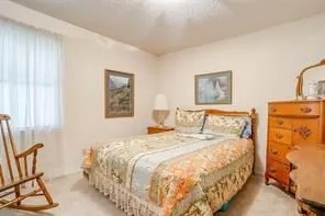 This room features a window with sheer white curtains and light-colored walls