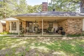 The property features a brick exterior with a covered patio area and a visible brick chimney