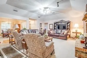 The property features a spacious living area with a vaulted ceiling, recessed lighting, and a ceiling fan