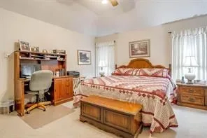 Spacious room featuring light-colored walls, a ceiling fan, and carpeted flooring