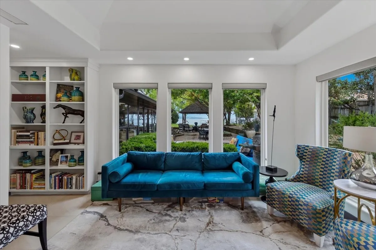  Office area featuring built-in shelving, large windows with views of the outdoors, and a tray ceiling