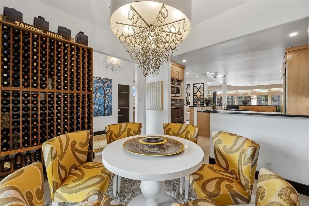  Dining area featuring a decorative chandelier, a round table, and a wine rack