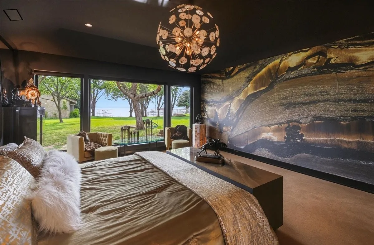 Primary BR with expansive windows offering serene views of the outdoors and a body of water