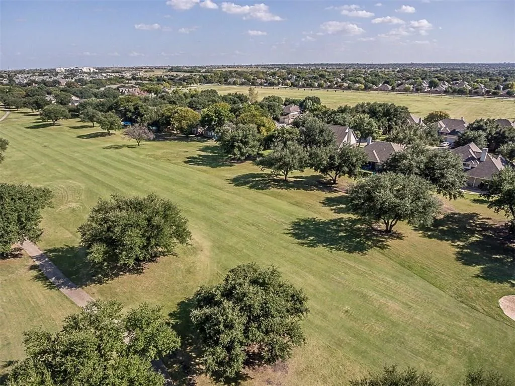 Aerial view showcasing the expansive green spaces, mature trees, and a golf course