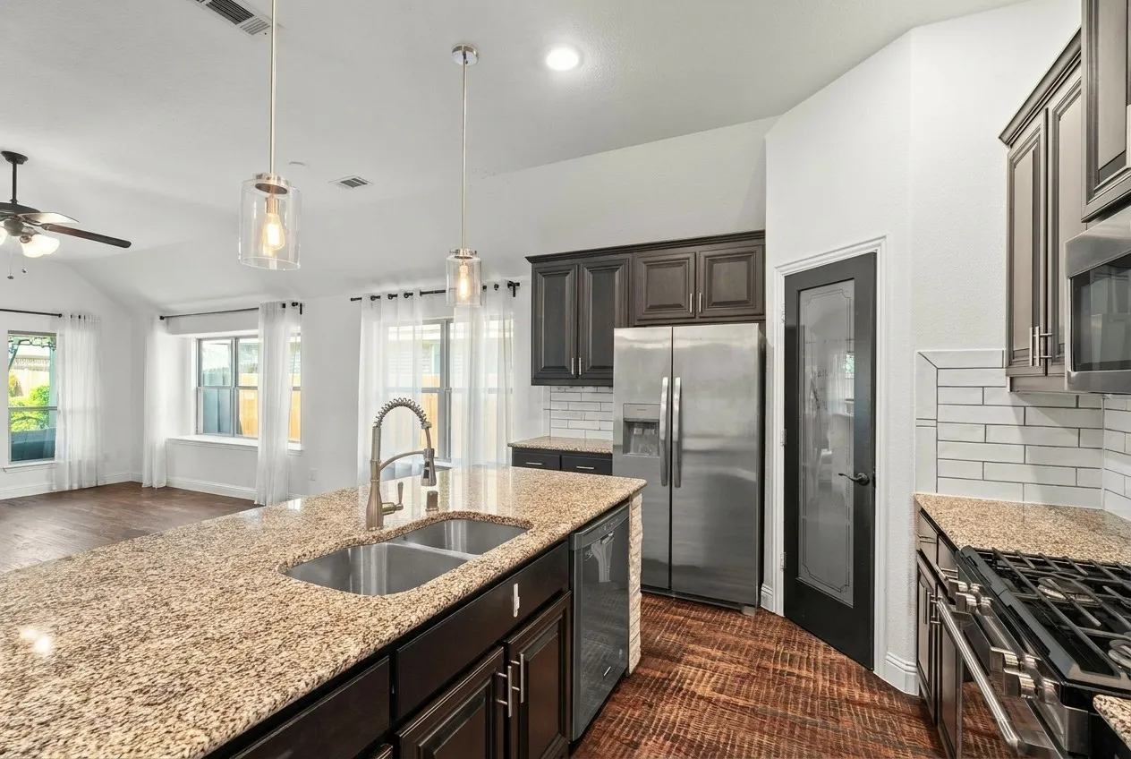 Kitchen with large island and stainless appliances.
