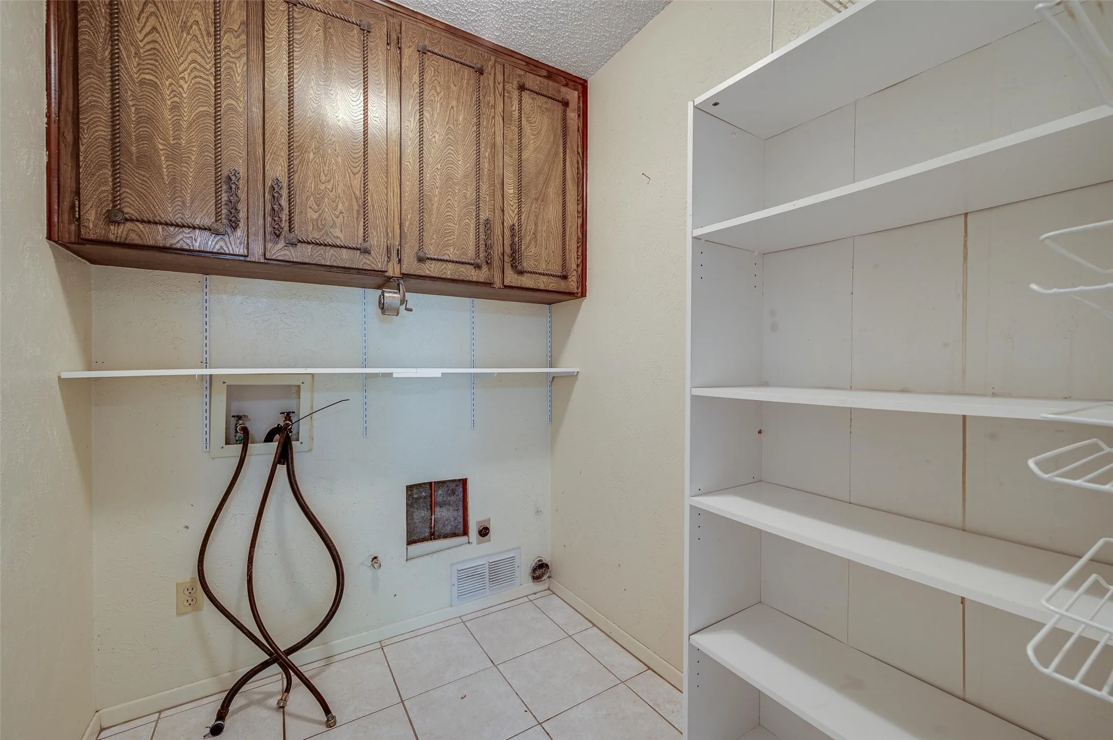 Laundry room with built in cabinets and extra storage area.