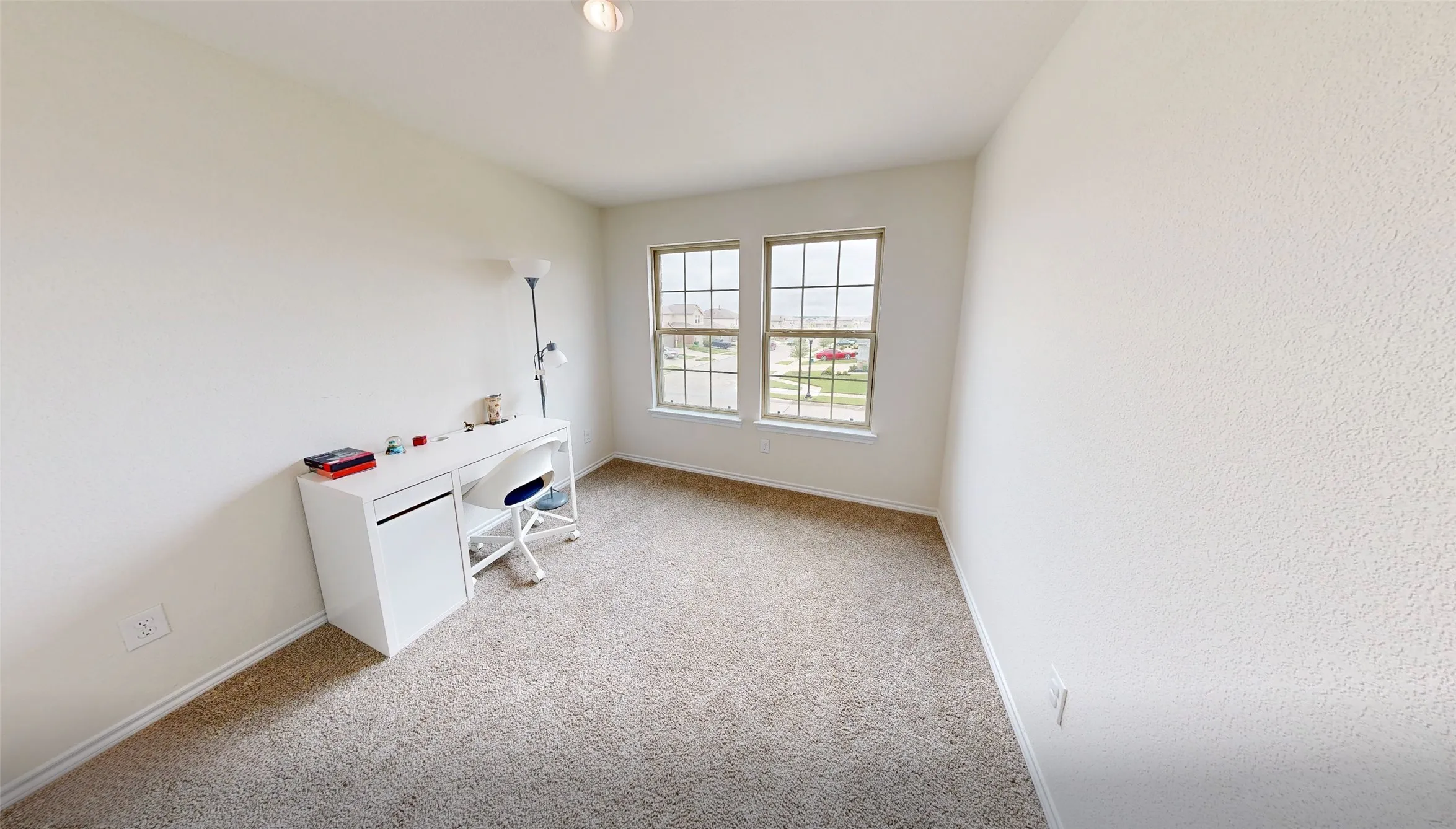 Carpeted room with two multi-pane windows, neutral wall finishes, and baseboard trim