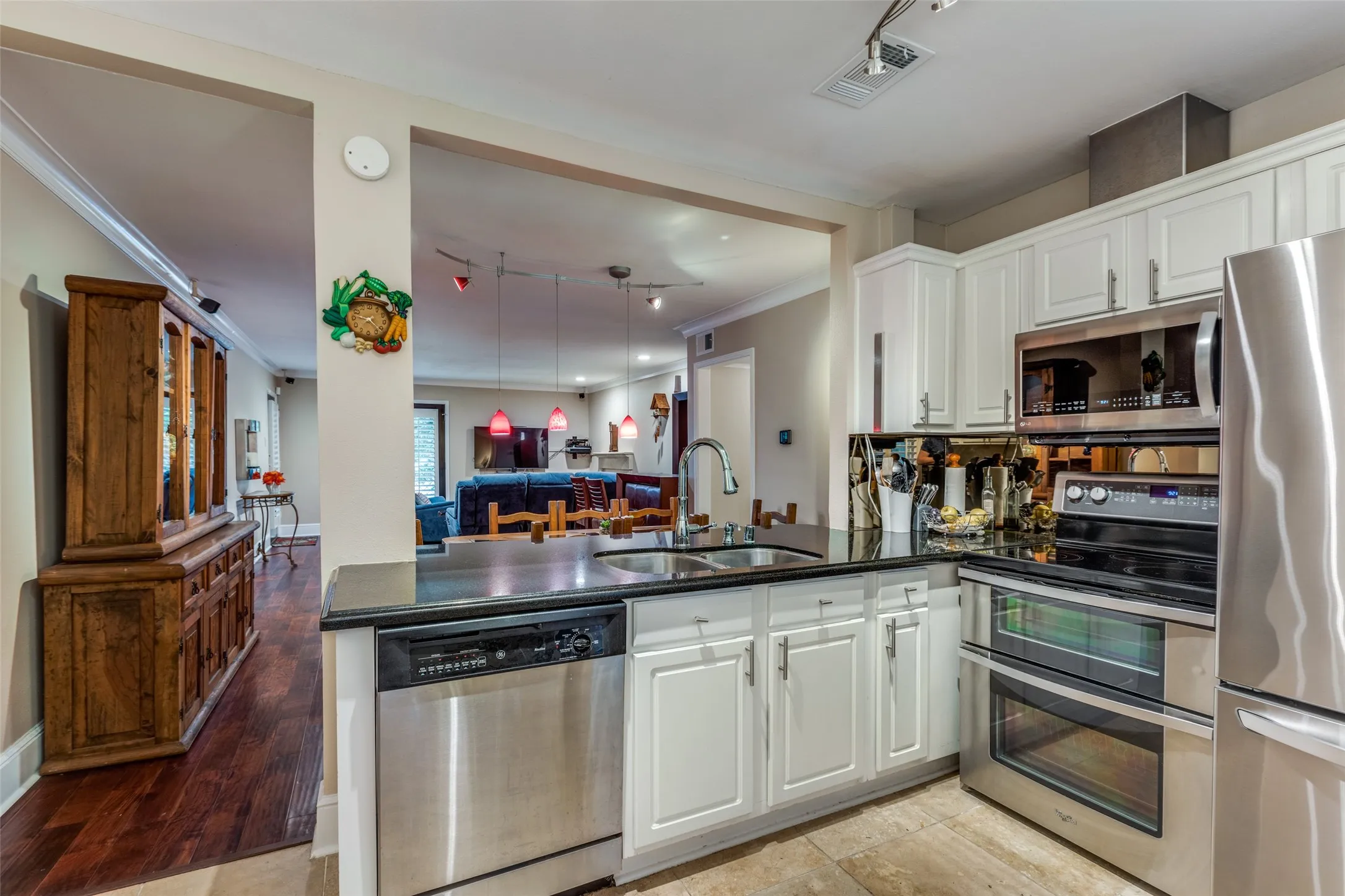 Kitchen featuring kitchen peninsula, appliances with stainless steel finishes and plenty of white cabinets for storage.