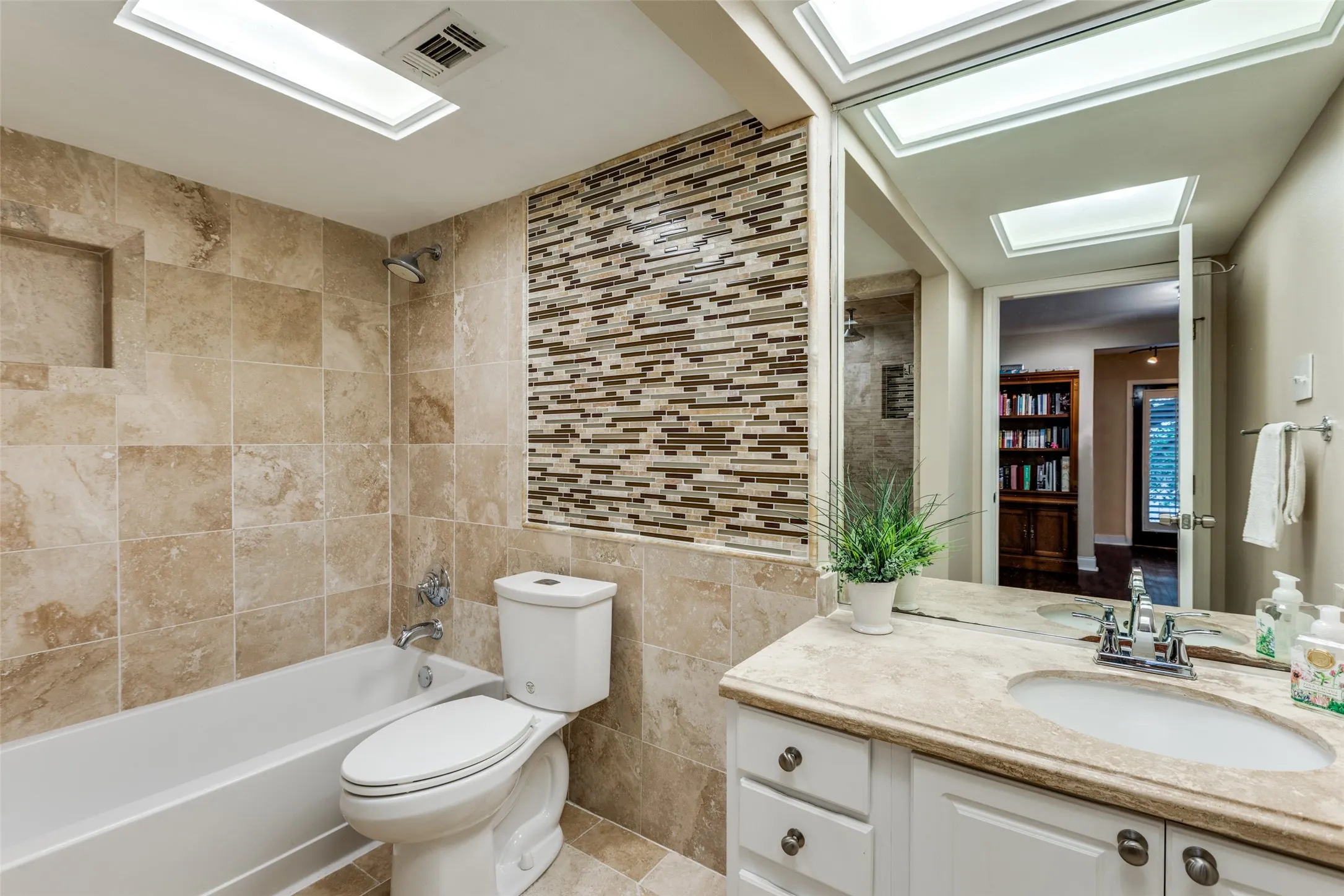 Full bathroom featuring tile flooring, tile walls, tiled shower / bath combo, toilet, and vanity