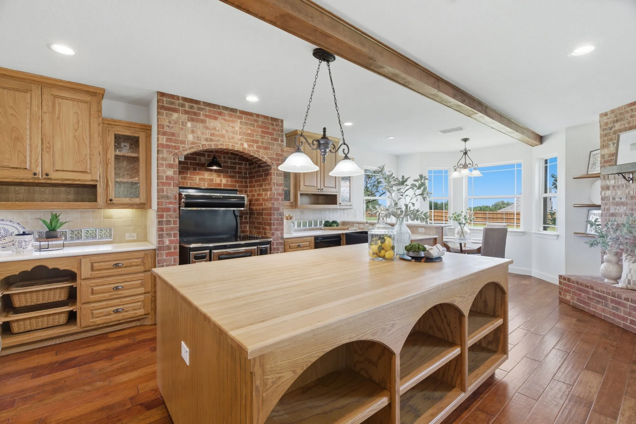 Designed with serious cooking and gathering in mind, the kitchen features an oversized island, brick range alcove and abundant prep and storage space.