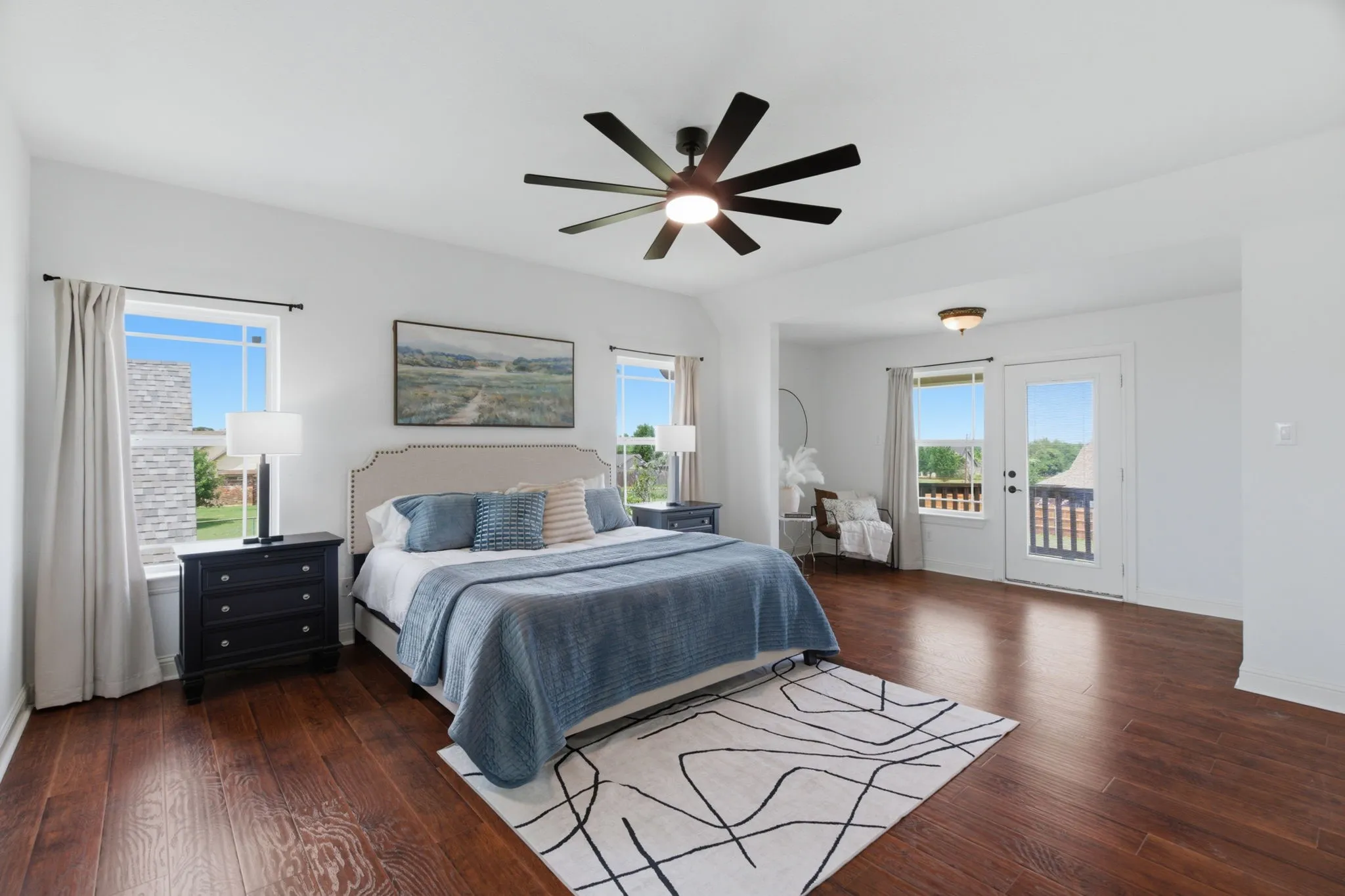 The spacious primary suite includes room for a sitting area, multiple windows and direct access to a private outdoor balcony.