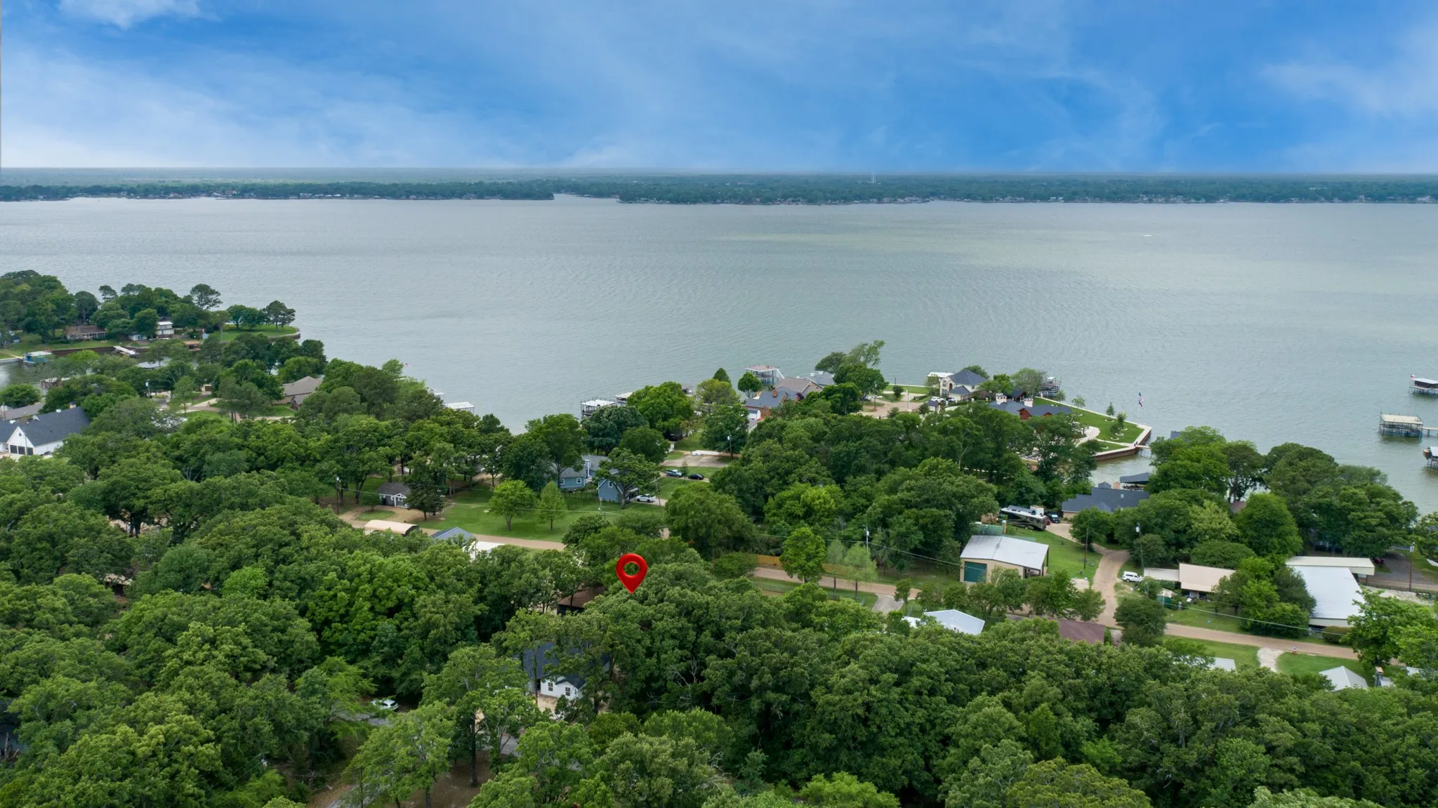 Aerial view of the property's location, showcasing a serene lake and lush green trees