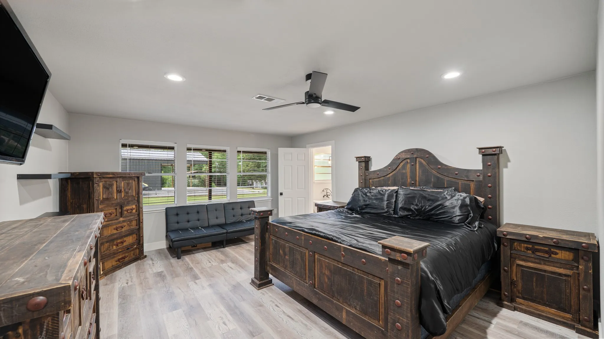 This room features light-colored flooring, recessed lighting, and a ceiling fan