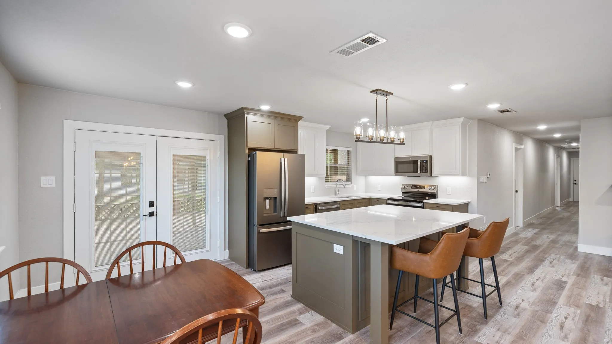 The property features an open-plan kitchen and dining area with modern appliances and light-colored flooring