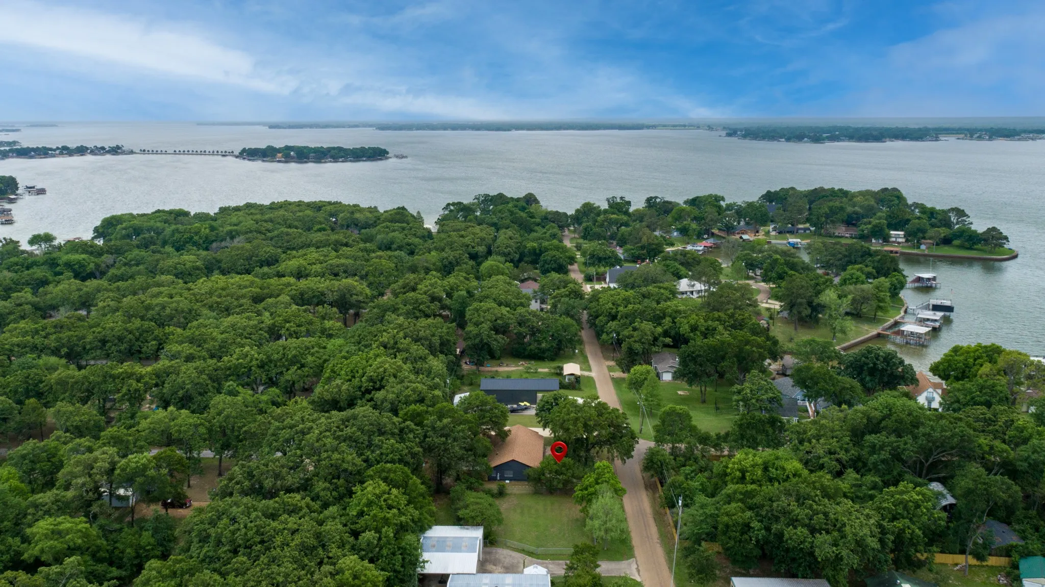 This aerial view showcases the property nestled within a wooded area, offering a serene environment