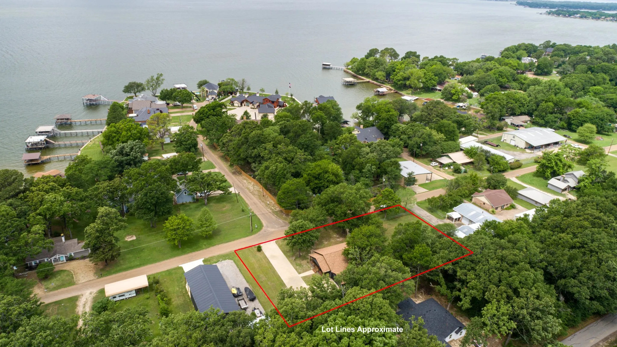 Aerial view of the property, showcasing its proximity to the lake and surrounding mature trees