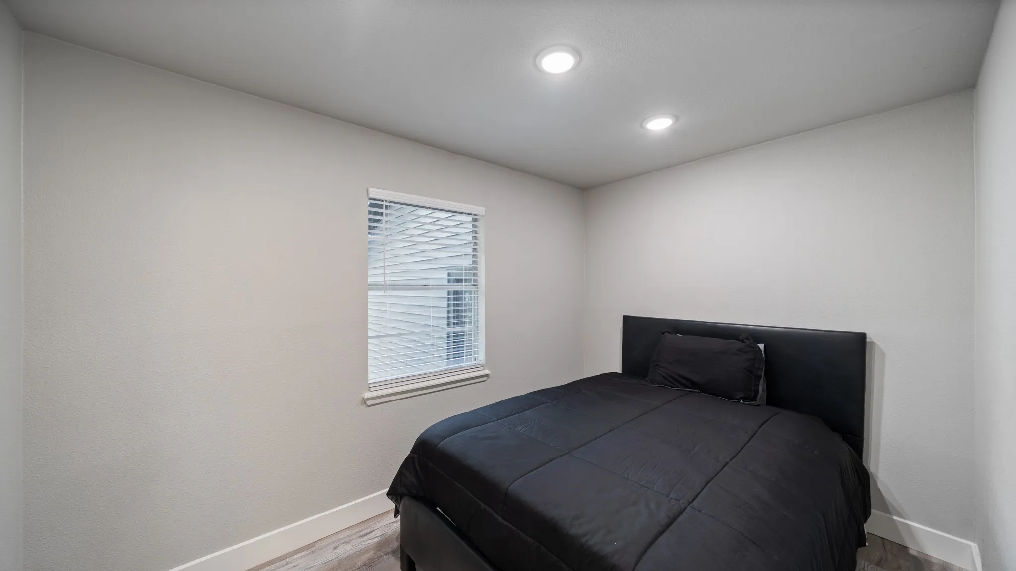 This room features recessed lighting, a window with blinds, and light-colored walls