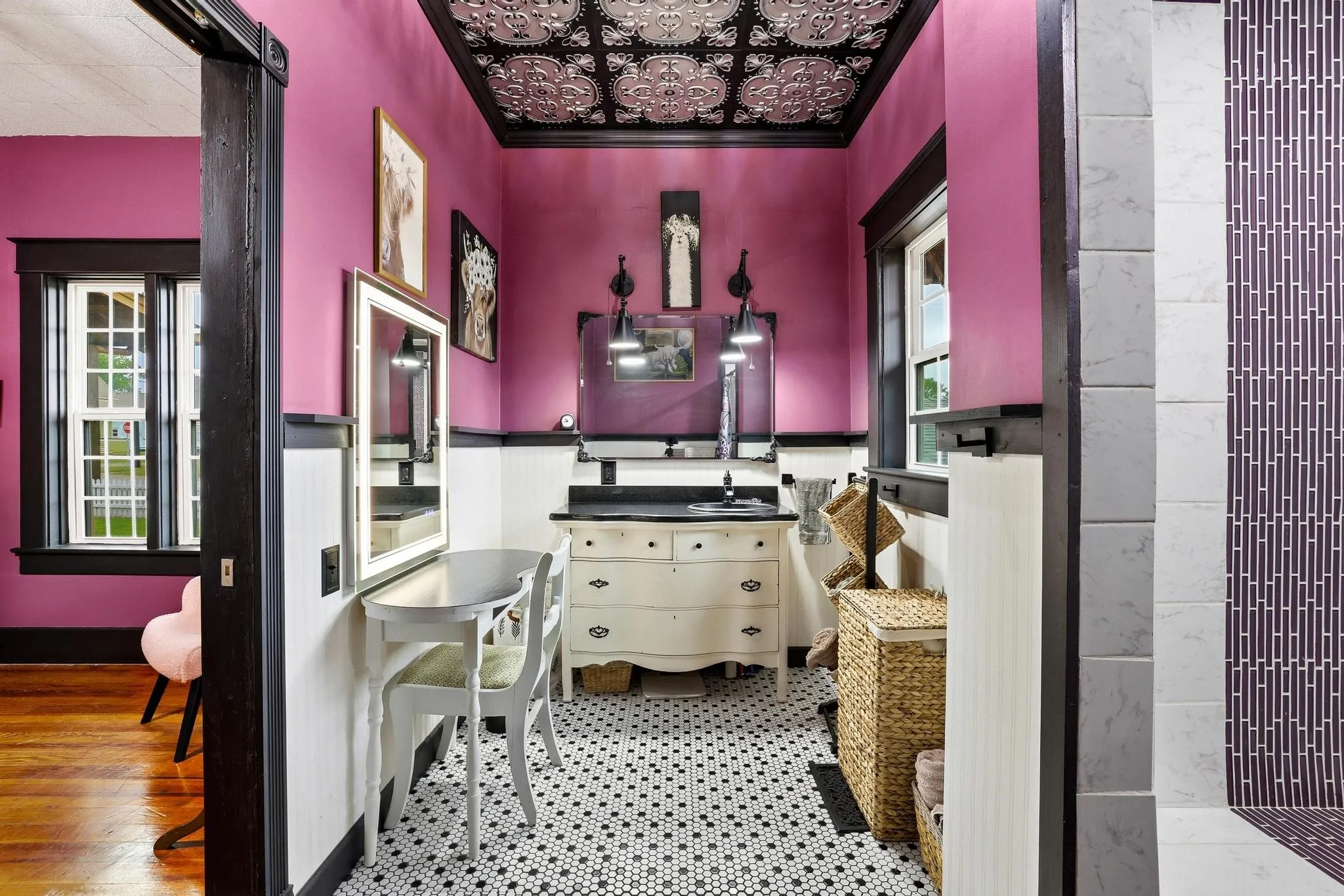 This room features a black and white tiled floor, a vanity with a sink, and a decorative ceiling
