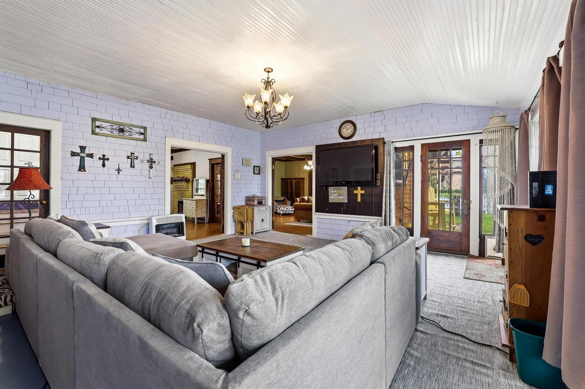 The property features light blue brick-style walls, a white paneled ceiling, and a chandelier with five lights