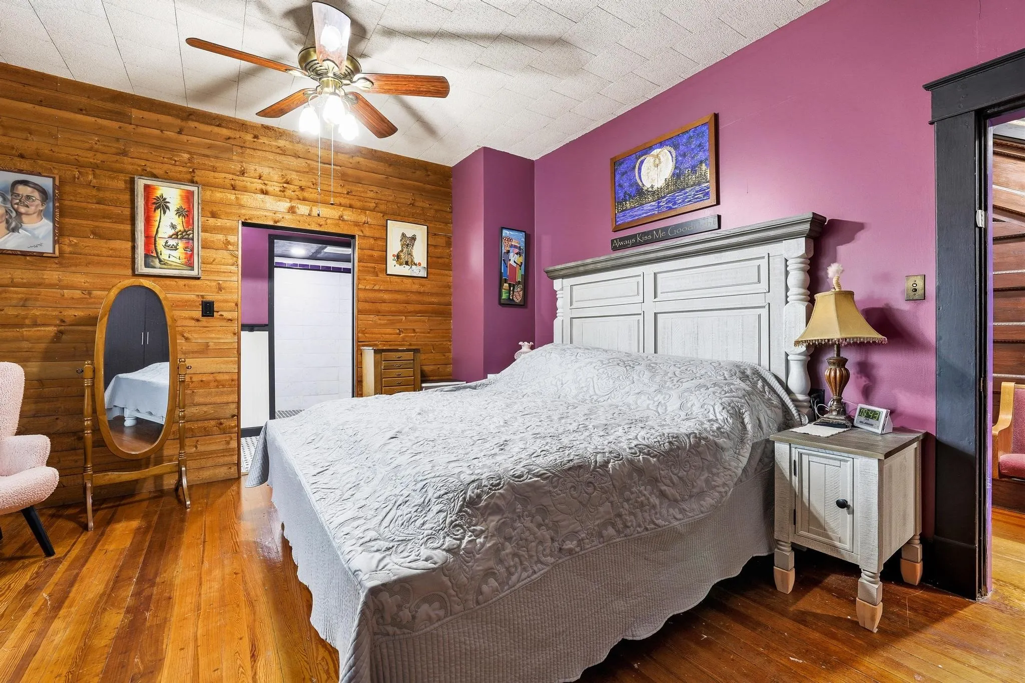 This room features rich hardwood flooring and a ceiling fan for comfort