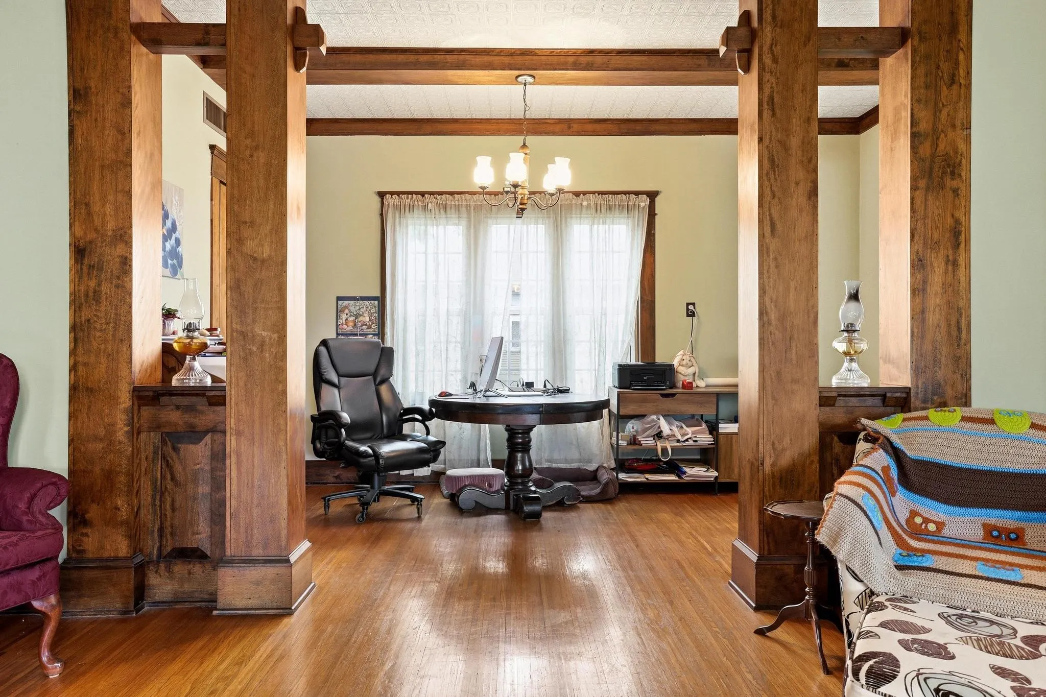 This property features hardwood floors throughout, accented by rich wooden columns and beams that define the space