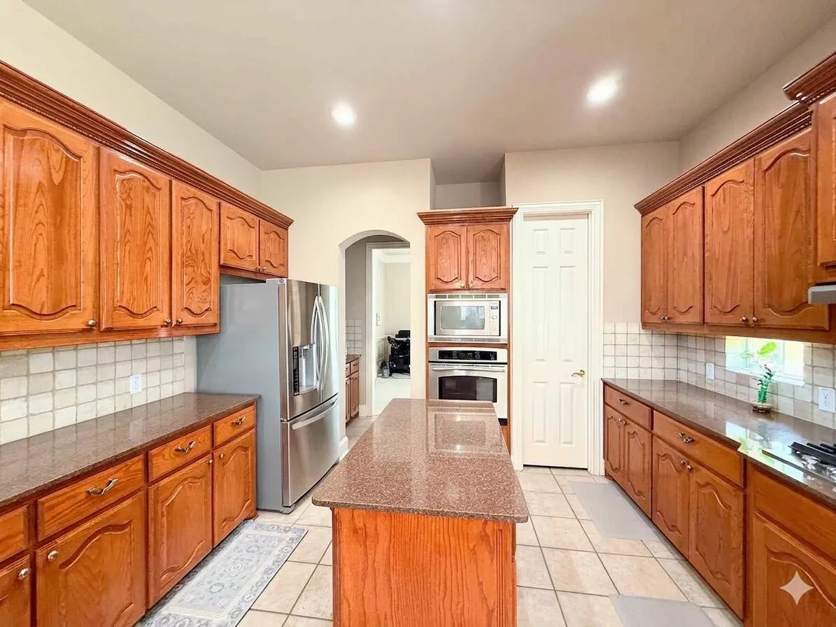 Kitchen featuring wood cabinetry, integrated stainless steel appliances, a center island with countertop, and tile flooring