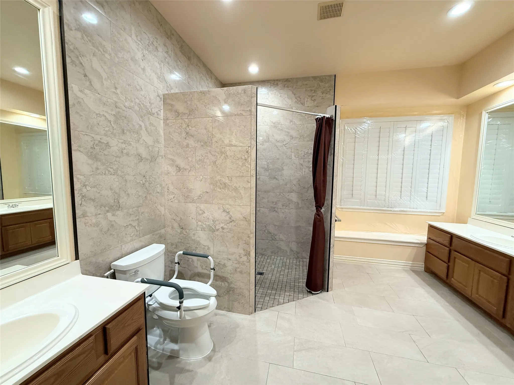 Spacious bathroom featuring an oversized walk-in shower with large format tile surround and mosaic tile flooring