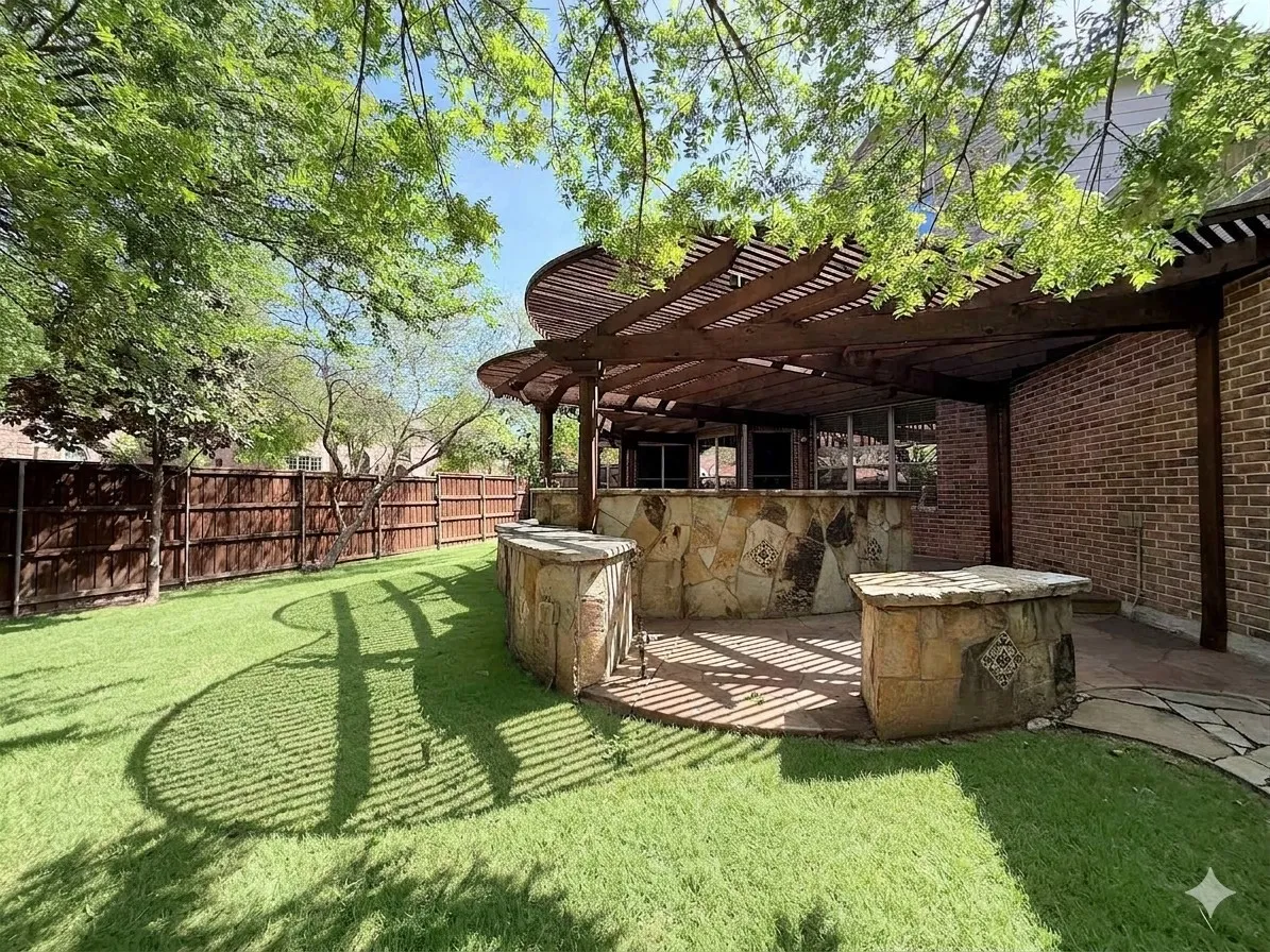 Expansive backyard featuring a manicured lawn, a full wooden privacy fence, and mature trees