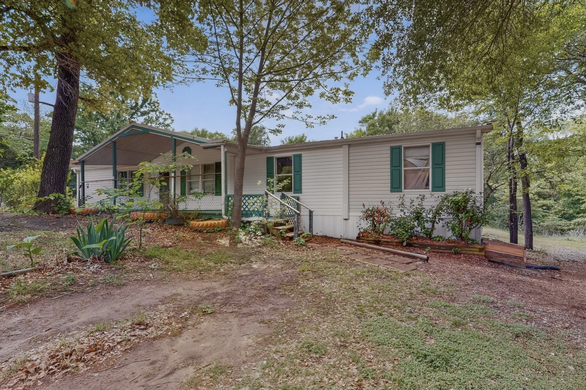 The property features a charming exterior with white siding, green shutters, and a covered porch